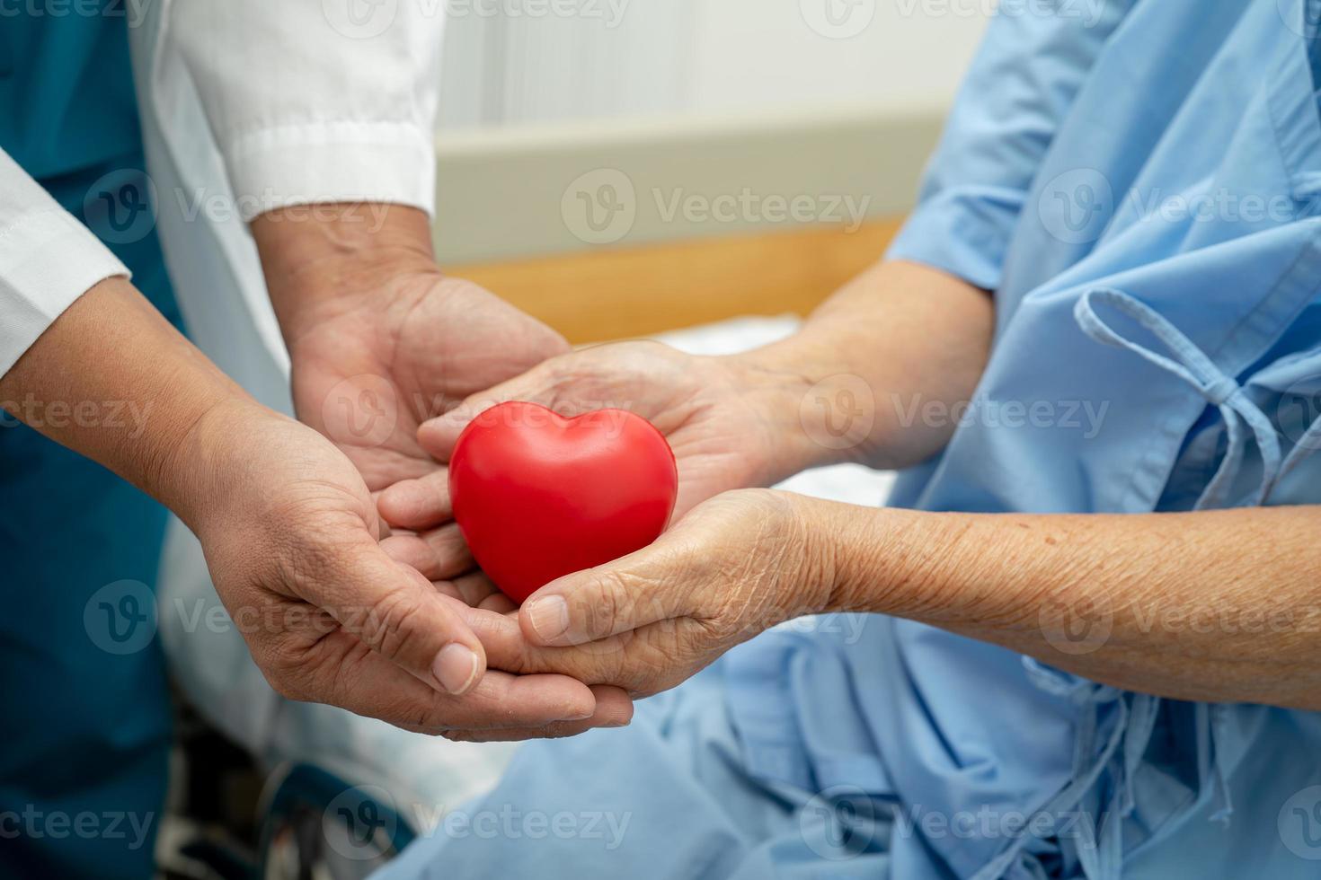 il medico dà il cuore rosso a una donna anziana o anziana asiatica paziente, sano concetto medico foto