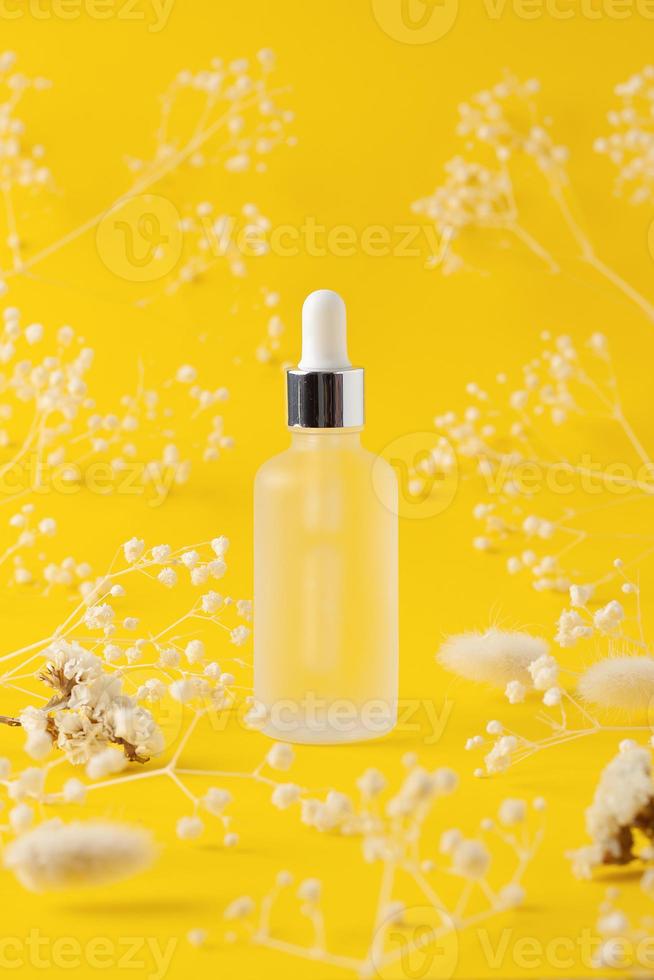 cosmetico bottiglia con fiori su giallo sfondo. vicino su foto