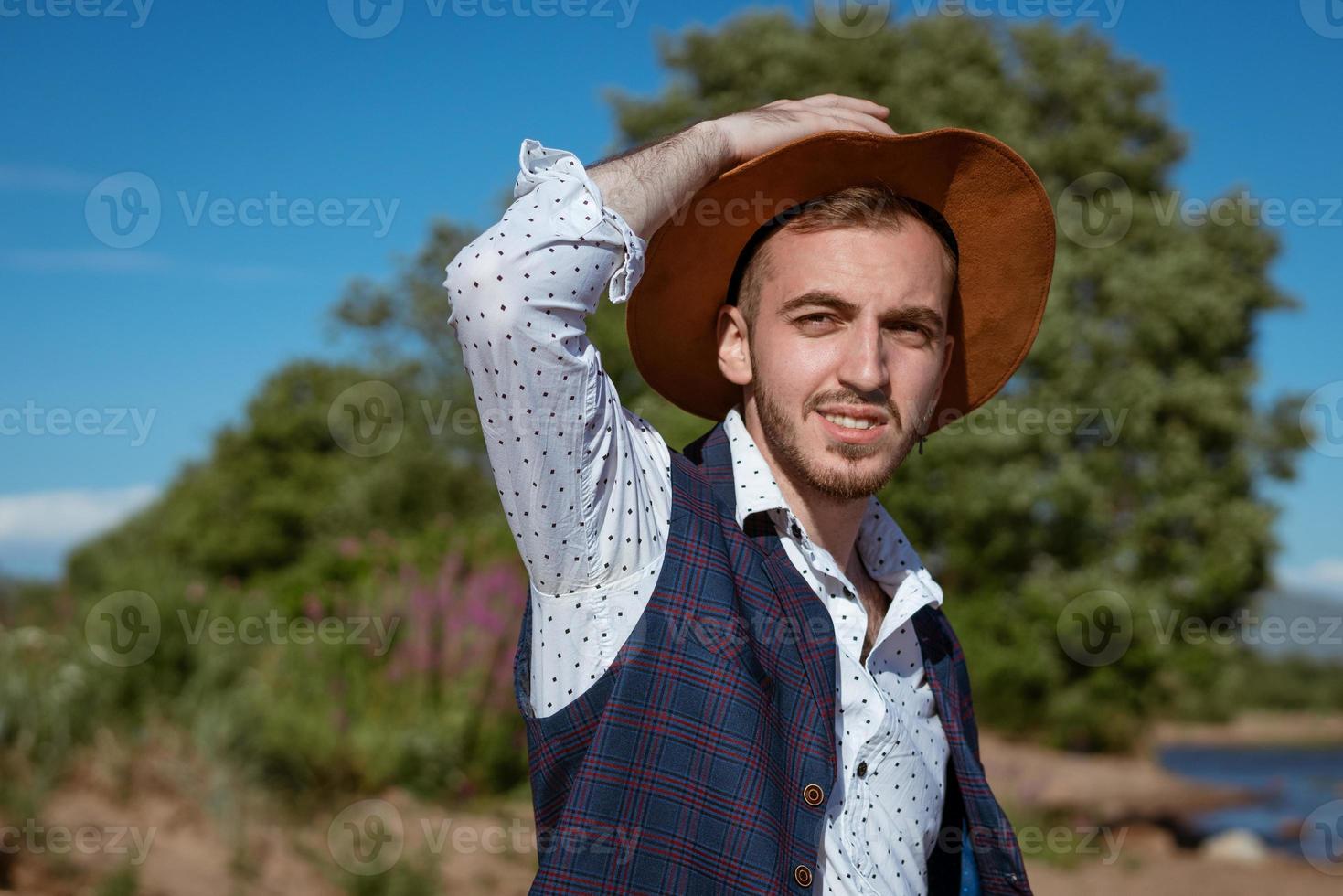 giovane uomo nel un' cappello su natura sembra per il lato foto