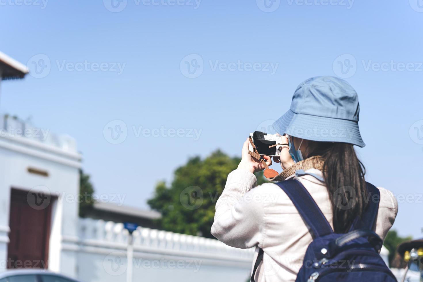 posteriore Visualizza giovane adulto asiatico donna viaggiatore utilizzando telecamera per foto viaggio.