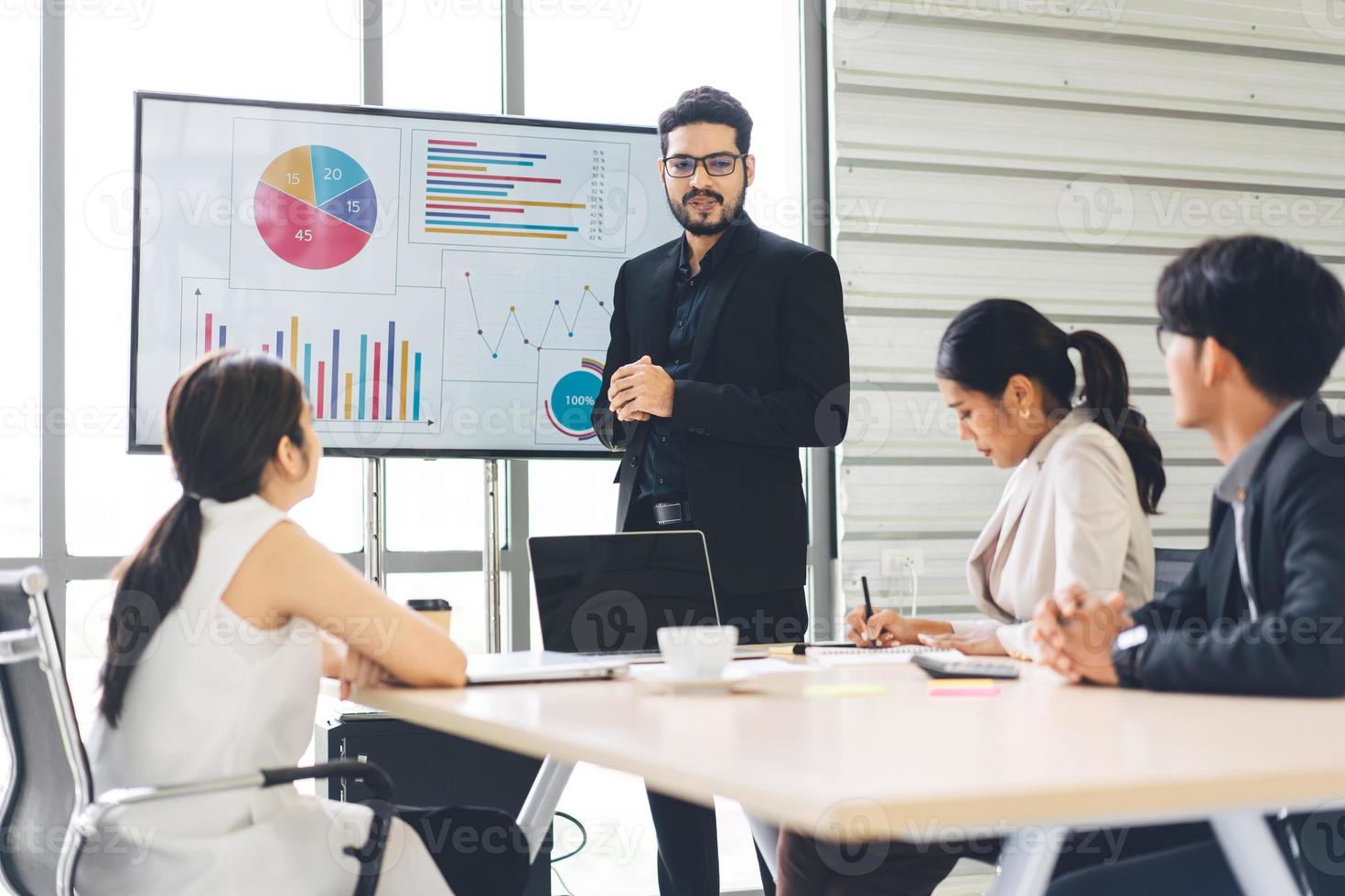 attività commerciale uomo con barba Amministratore delegato Guarda presentazione e breve strategia con squadra nel sala del consiglio foto