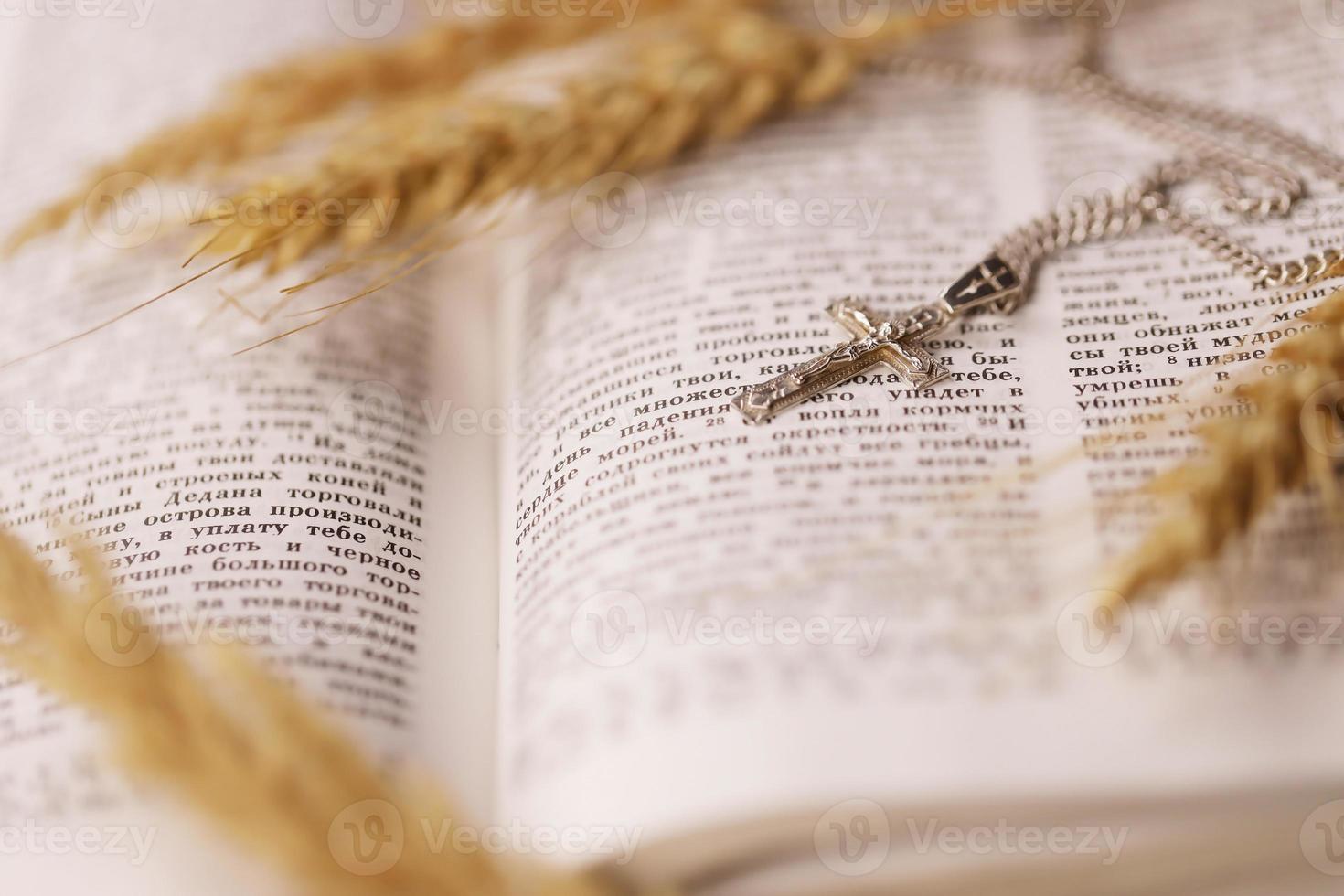 argento collana con crocifisso attraversare su cristiano santo Bibbia libro su nero di legno tavolo. chiede benedizioni a partire dal Dio con il energia di santità foto
