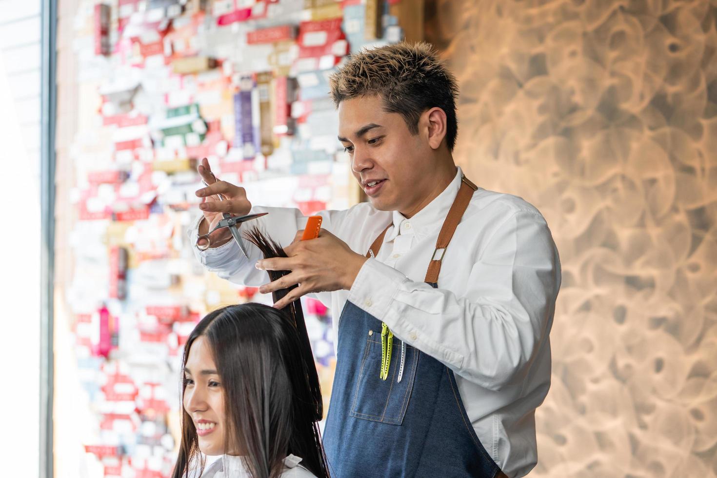 asiatico capelli elegante con giovane donne cliente mentre fare capelli tagliare o capelli trattamento e messa in piega capelli per cliente. professionale occupazione, bellezza e moda servizio. foto