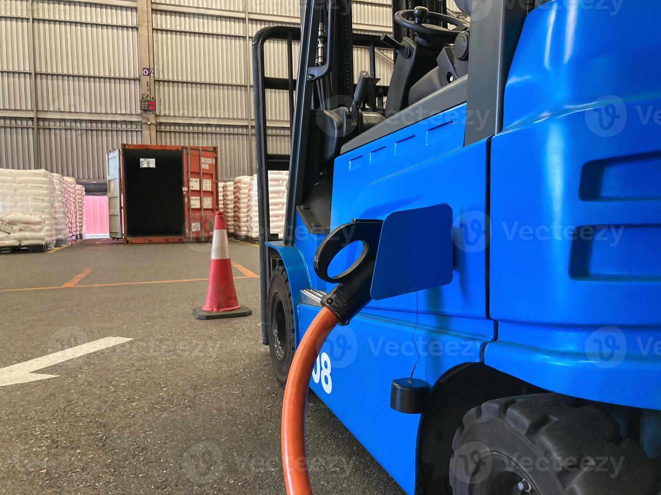 elettrico carrello elevatore a forca veicolo parco e spina nel per ricarica batteria dentro di logistica magazzino. alternativa energia fonte per auto e macchina nel industriale attività commerciale segmento. settore automobilistico tecnologia. foto