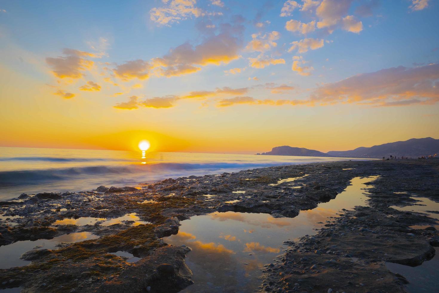 Visualizza di un' roccioso costa nel tramonto. tramonto mare roccia paesaggio nel lungo esposizione tiro foto