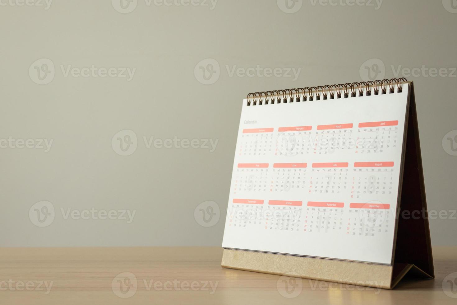 calendario pagina vicino su su legna tavolo con bianca parete sfondo attività commerciale pianificazione appuntamento incontro concetto foto