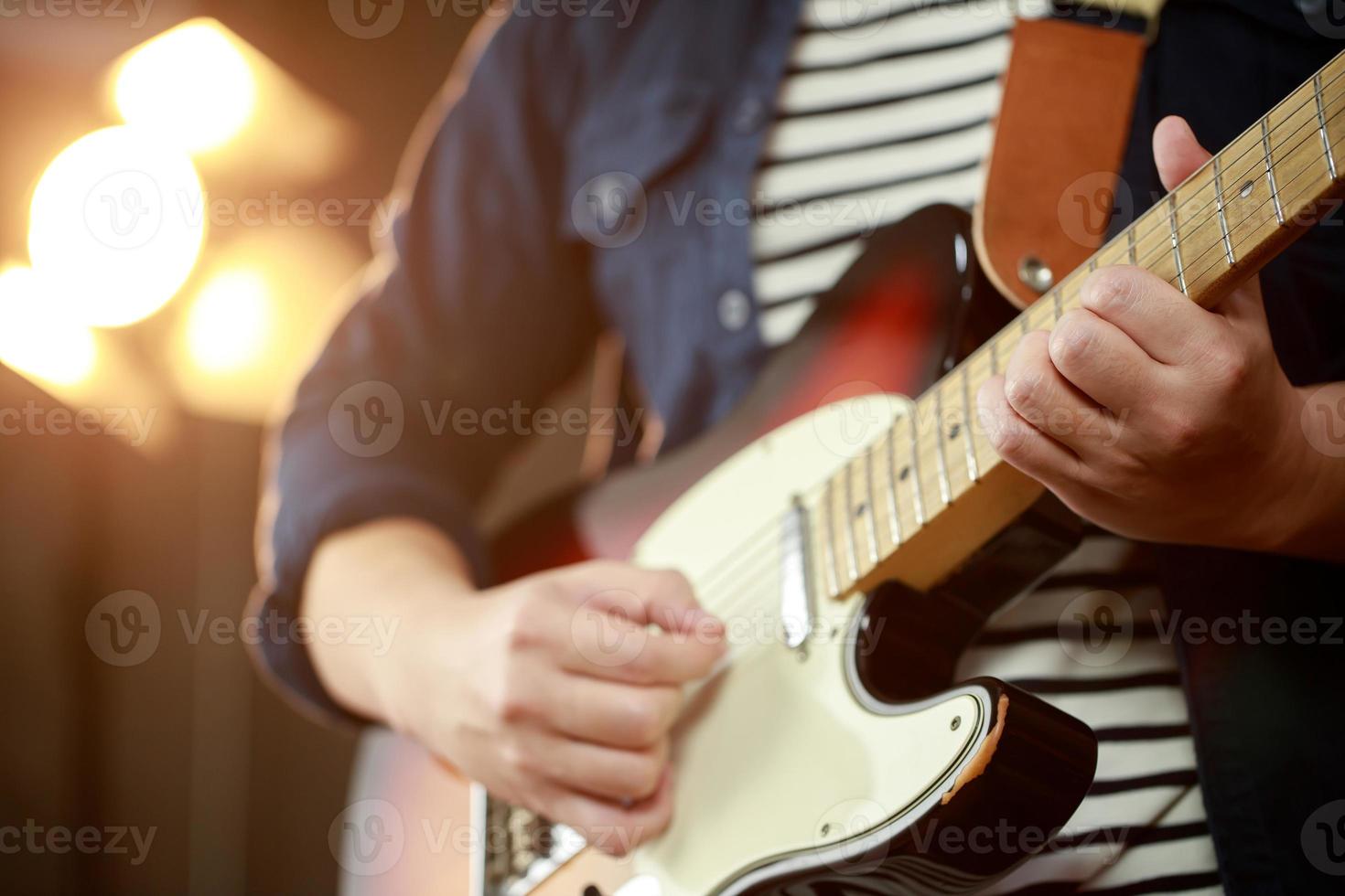 un' musicista giochi un elettrico chitarra a un' concerto. foto