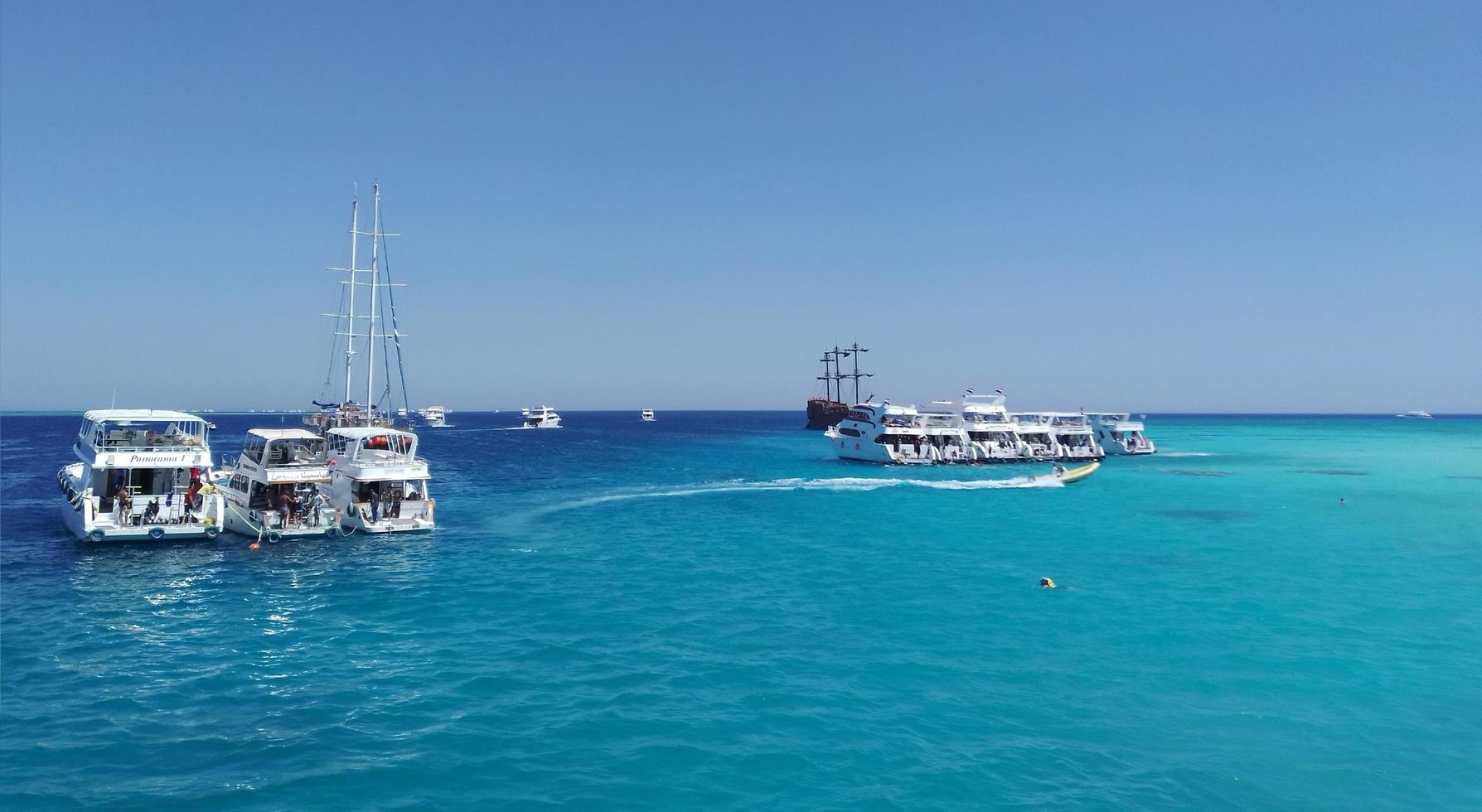 yacht parcheggio con turisti vicino bianca isola nel rosso mare. Egitto foto