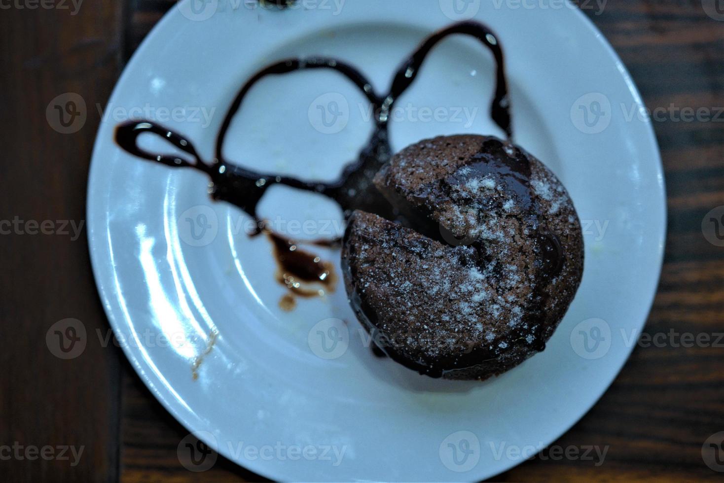 cioccolato focaccina torta su superiore di un' piatto con cioccolato salsa foto