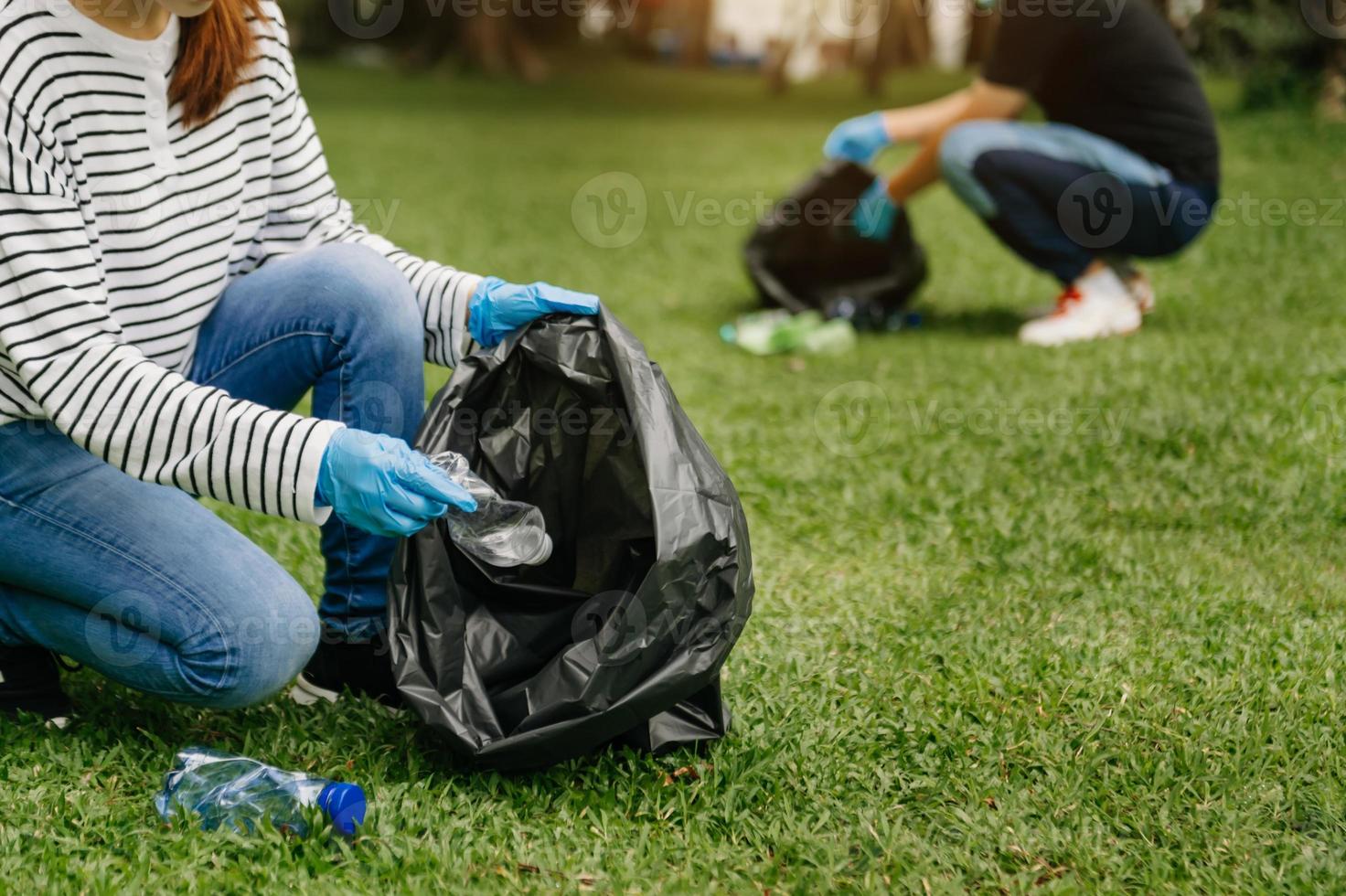 donna di mano scelte su plastica rifiuto per pulizia in riciclare Borsa per pulizia il parco. radura, inquinamento, ecologia concetto. foto