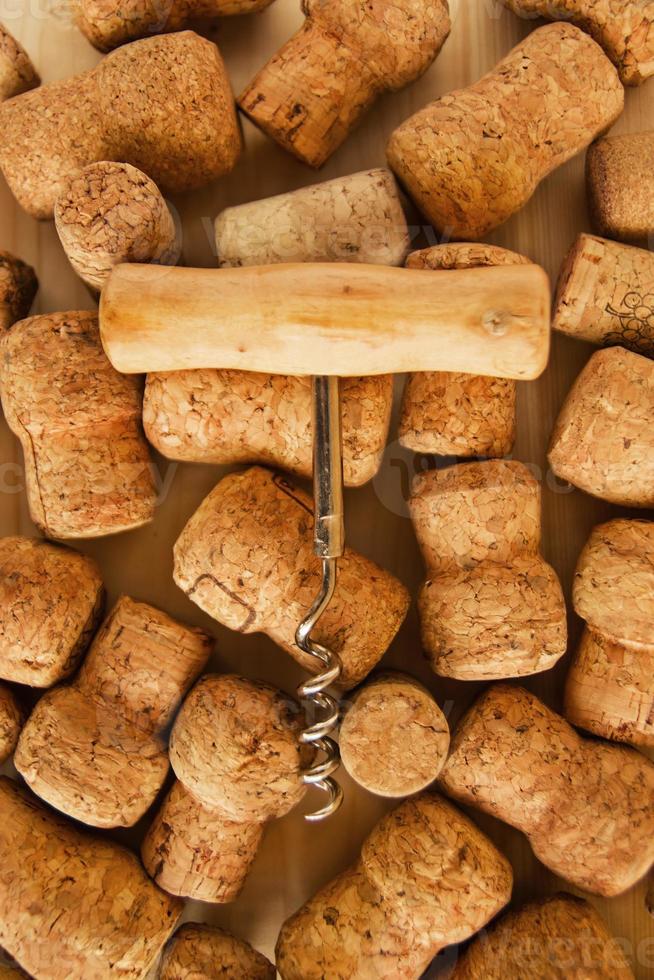 un' lotto di vino tappi e cavatappi su il di legno sfondo, superiore Visualizza. foto