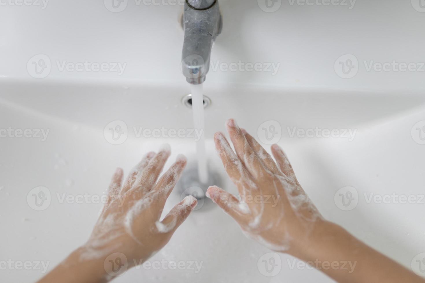 poco asiatico ragazze lavare loro mani nel il bagno. morbido messa a fuoco. copia spazio. foto