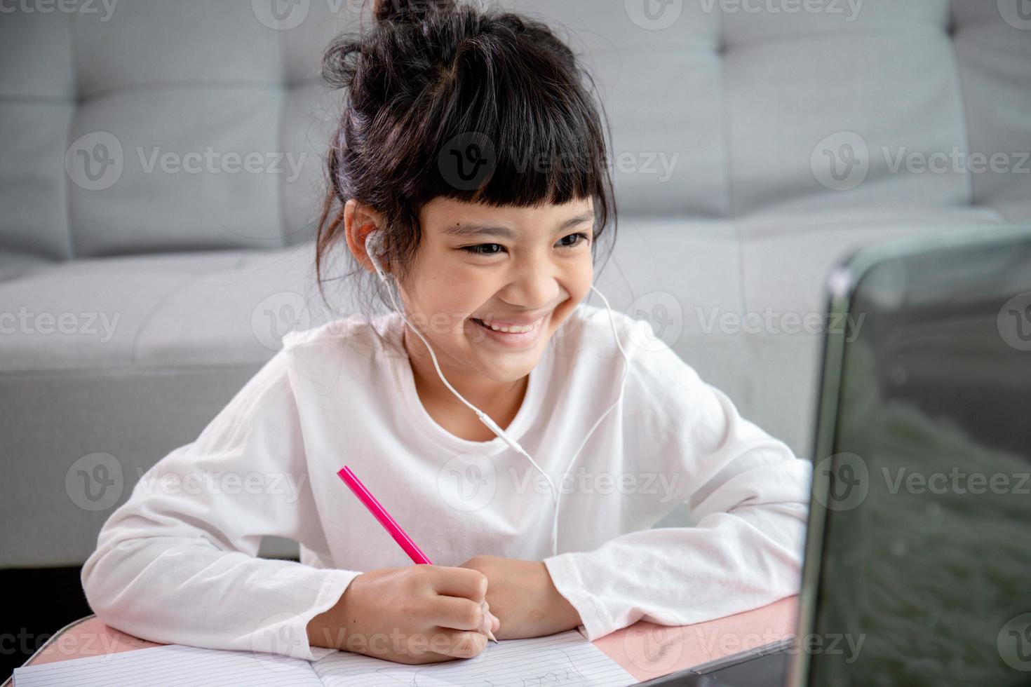 asiatico ragazza studenti indossare cuffie studia in linea con video chiamata il insegnante, contento giovane ragazza apprendimento terra ecologia ascolta conferenza orologio Scrivi Appunti Guarda a il il computer portatile a casa.covid-19 coronavirus. foto