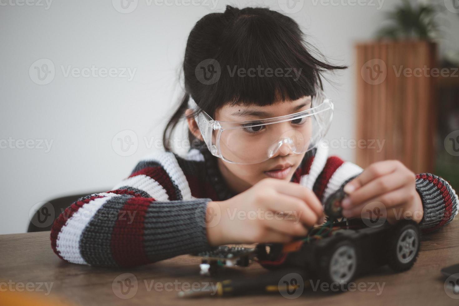 poco ragazze avendo divertimento nel un' laboratorio codifica robot auto foto