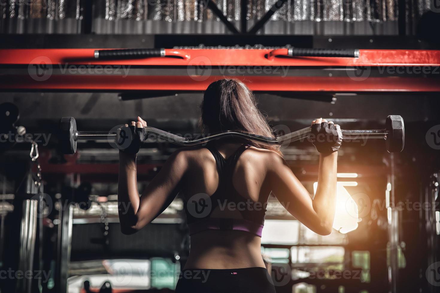 giovane donna fitness eseguire esercizio con macchina per esercizi in palestra foto