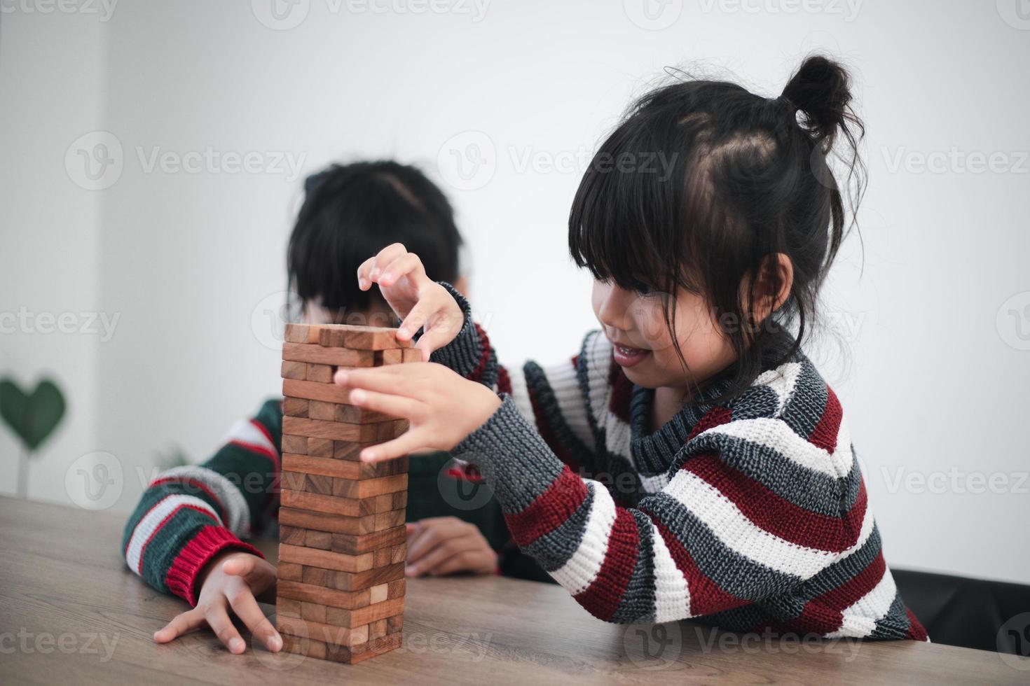 allegro asiatico ragazza giocando con di legno edificio blocchi. avendo divertimento e apprendimento creatività. inteligente ragazzo concetto. foto