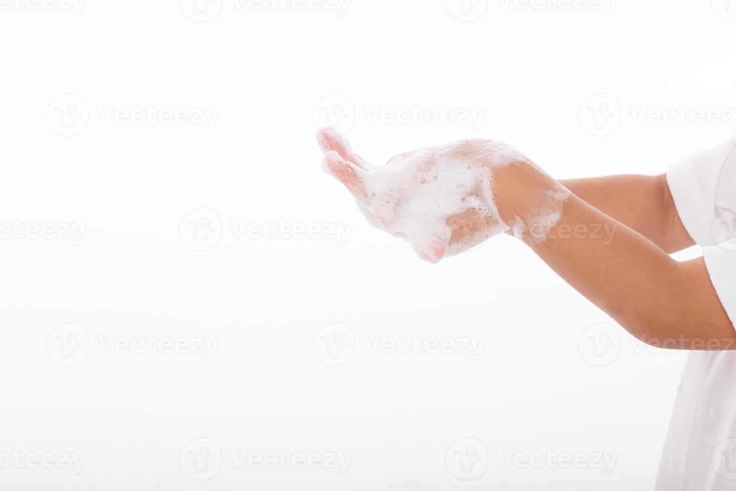 poco ragazza mano lavaggio mani su bianca sfondo foto