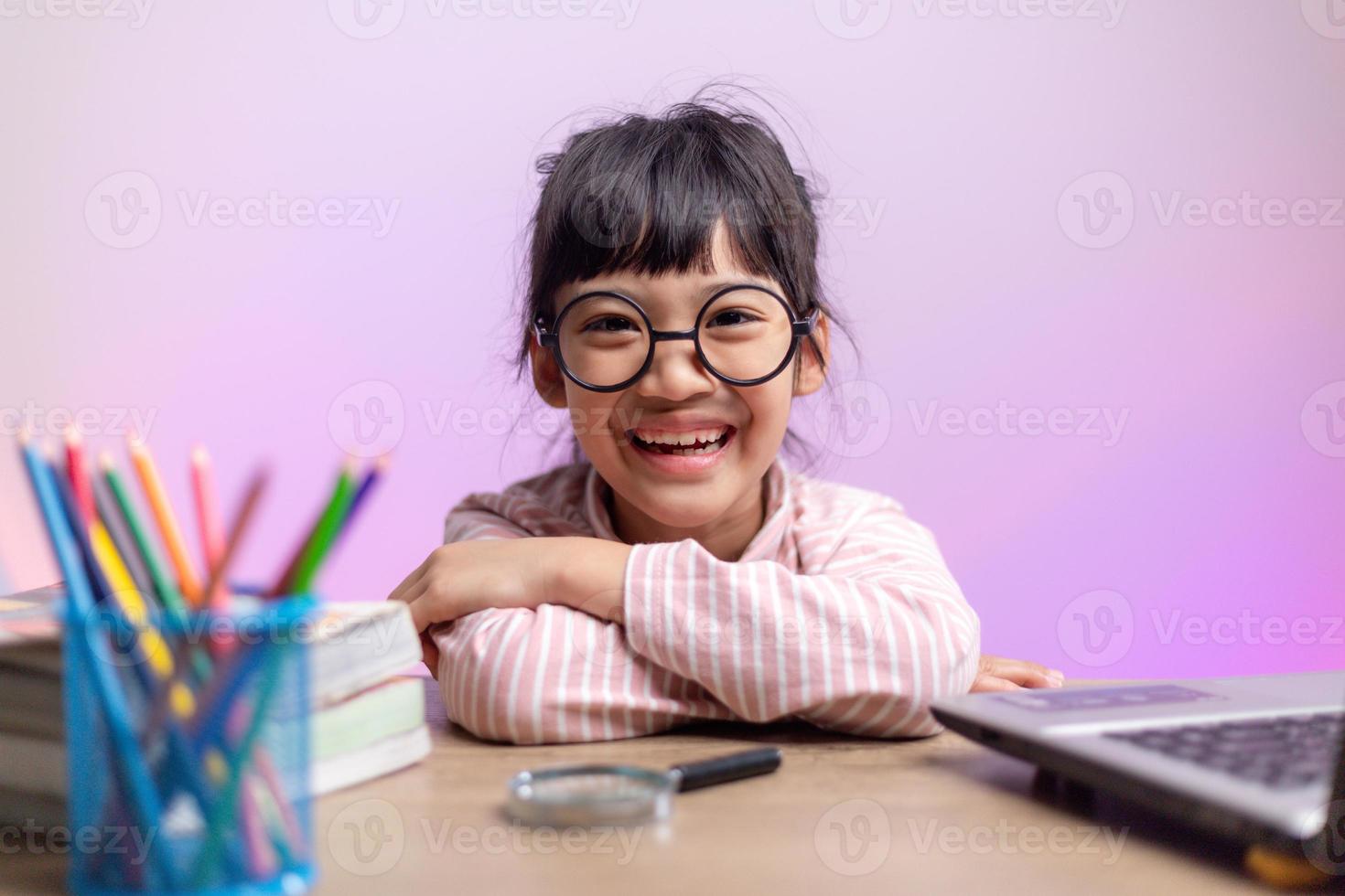 asiatico ragazza seduta e studiando a casa su un' il computer portatile per studia a partire dal casa durante covid-19 pandemia confinamento. in linea formazione scolastica, homeschooling foto