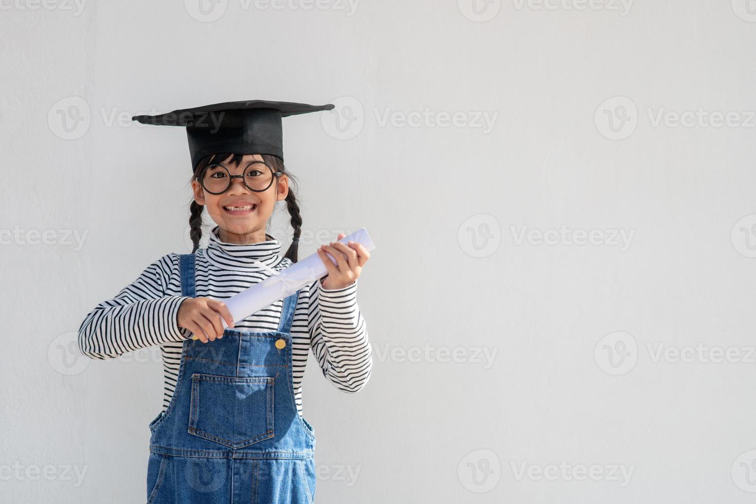 contento asiatico scuola ragazzo diplomato nel la laurea berretto foto