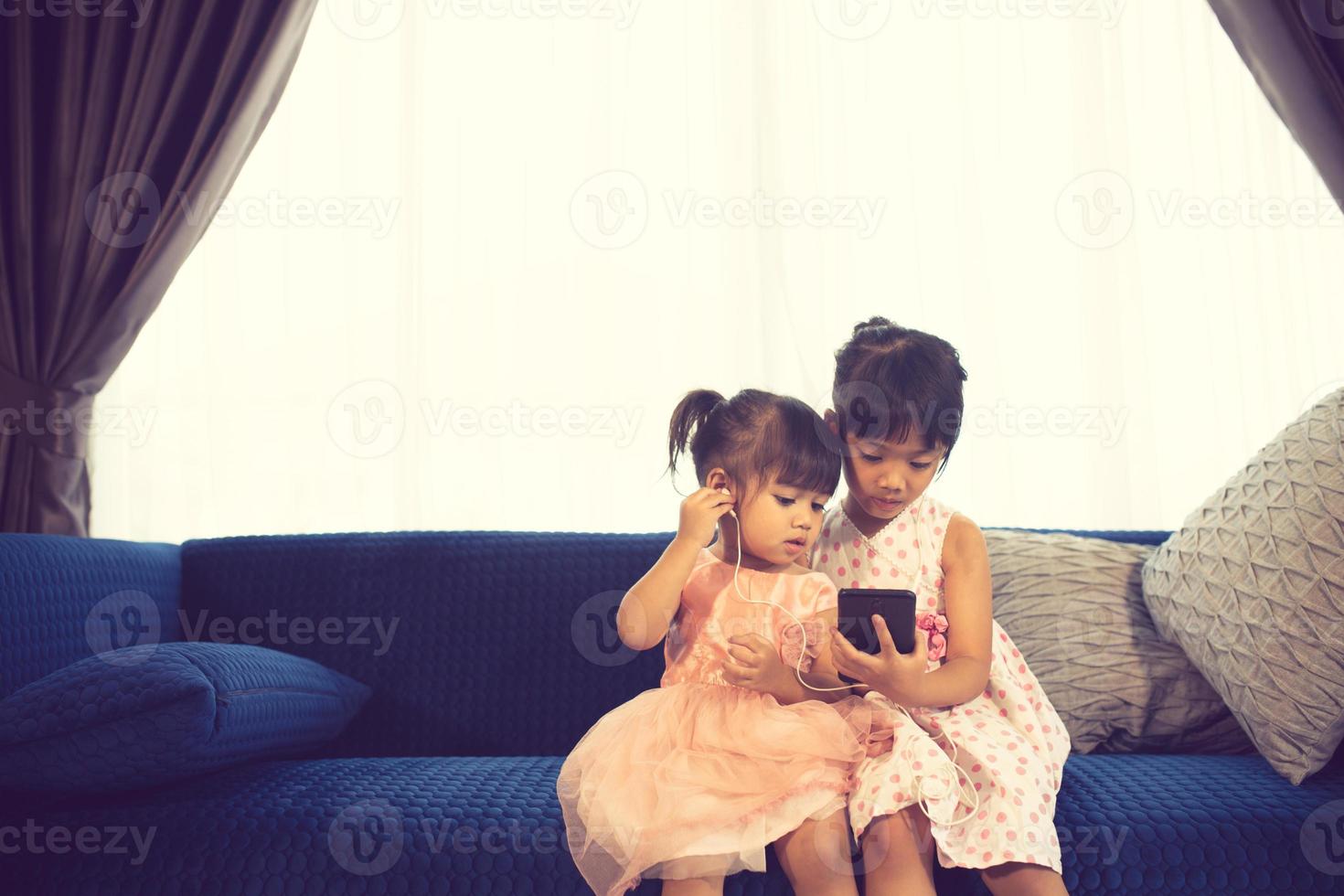 bambini che ascoltano musica seduti su un divano foto