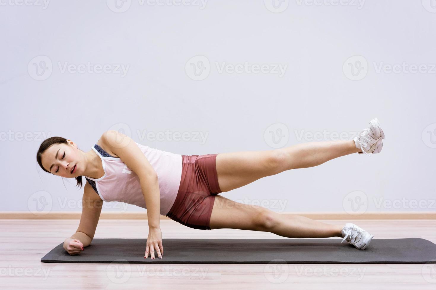 donna che fa fitness a casa sullo sfondo del muro foto