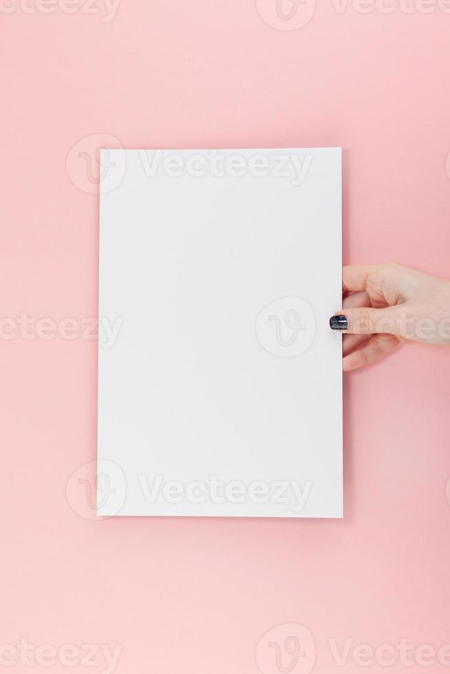 mani di donna con mockup di foglio di carta a4 vuoto foto