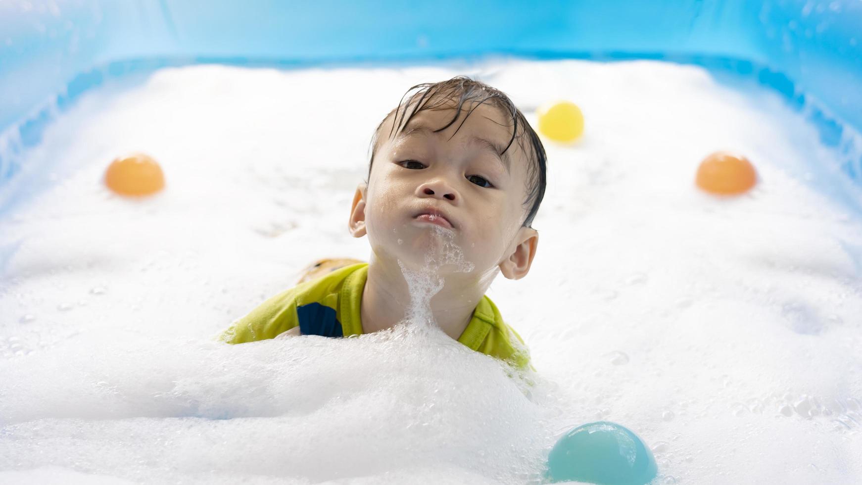 carino poco asiatico ragazzo nuoto nel bolle nel un gonfiabile piscina. estate acqua giocare a, famiglia felicità, figli di felicità, piscina e multicolore palle foto