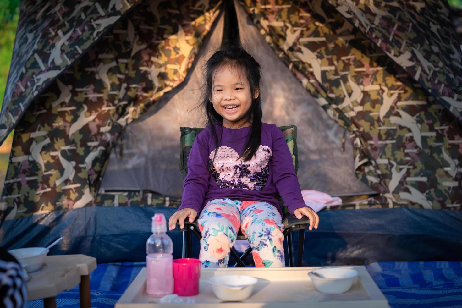 bambina su una sedia da campeggio foto