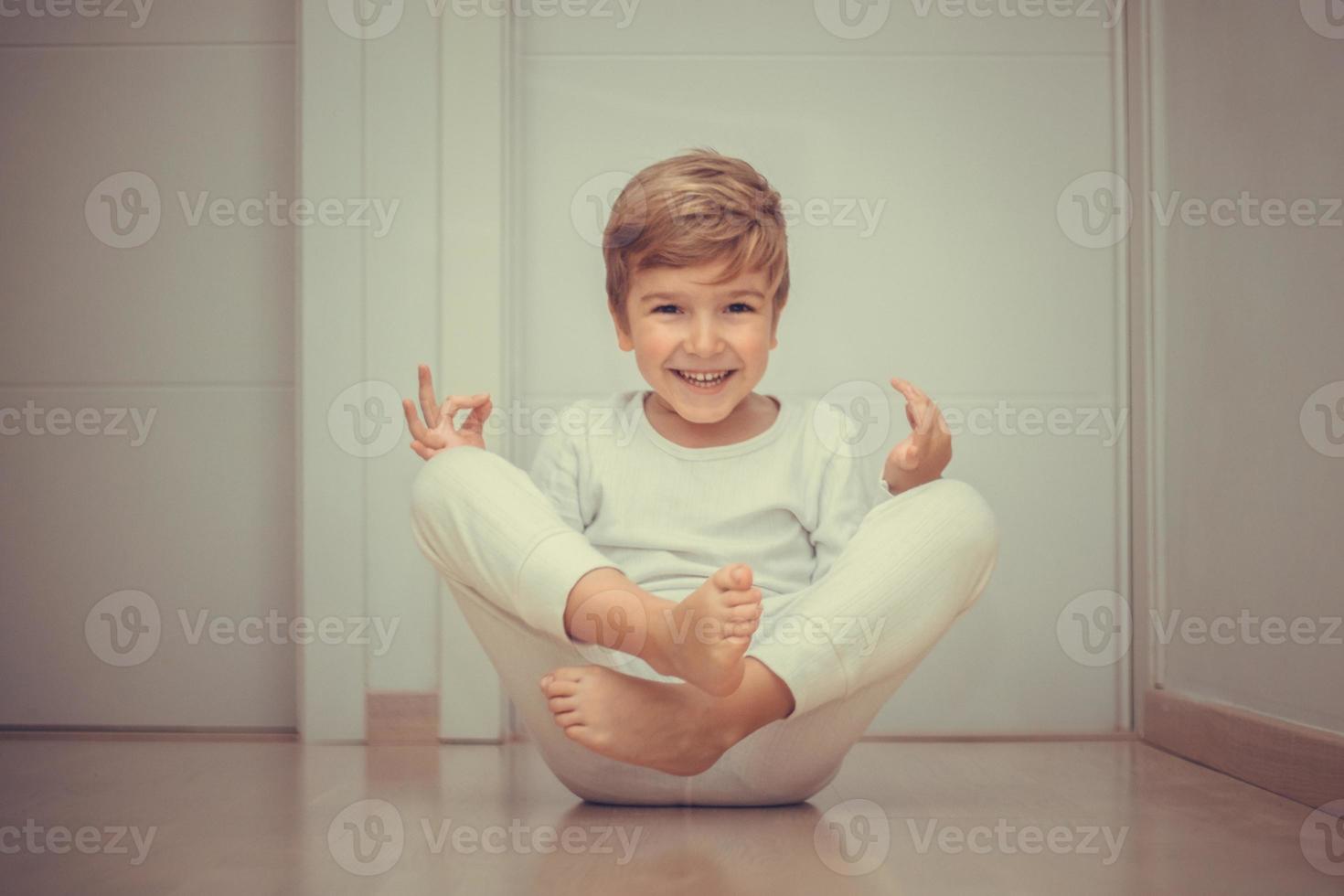 allegro ragazzo avendo divertimento mentre praticante yoga. foto