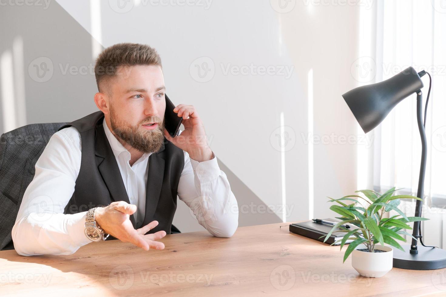 bene notizia. contento caucasico uomo d'affari nel camicia parlando su Telefono con cliente foto