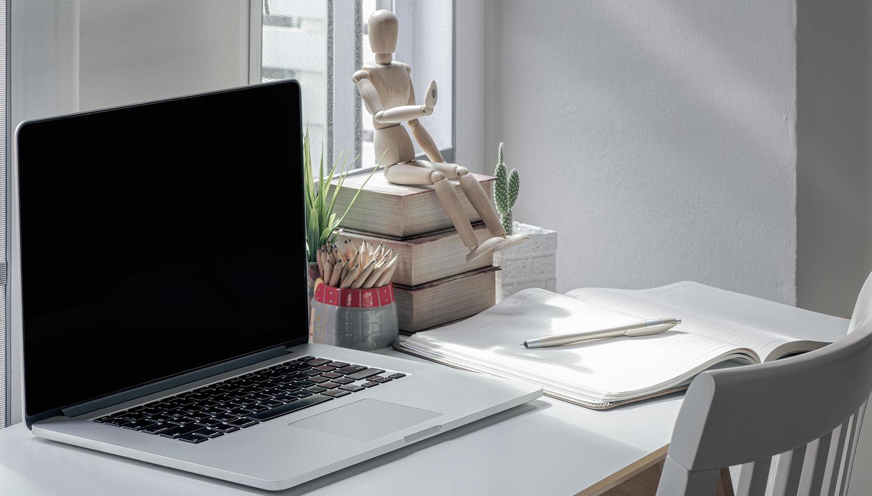 area di lavoro con un laptop e forniture su un tavolo foto