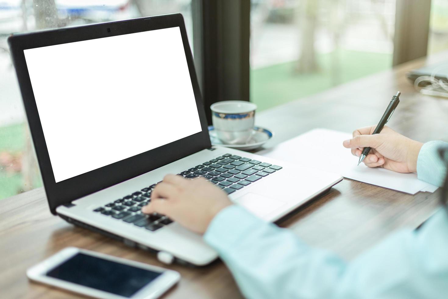 primo piano di una persona che lavora su un computer portatile foto