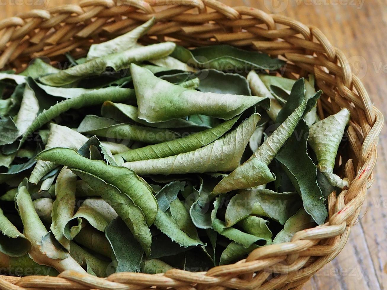 vicino su secco kaffir lime le foglie nel un' bambù intrecciata cestino foto