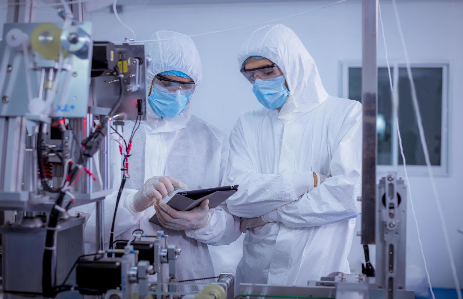 tecnico lavoratore indossare protettivo suite , guanto siamo ispezionare ione con dai un'occhiata viso maschera produzione processi per sicuro e contro a partire dal virus. foto