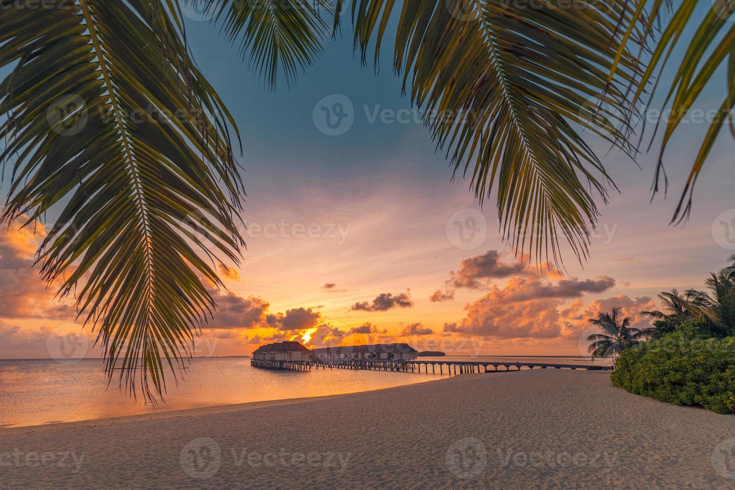 fantastico isola spiaggia e tramonto cielo con palma albero le foglie. lusso tropicale spiaggia paesaggio, di legno molo in al di sopra di acqua ville, bungalow sorprendente scenico. vacanza ricorrere, esotico Hotel paesaggio foto