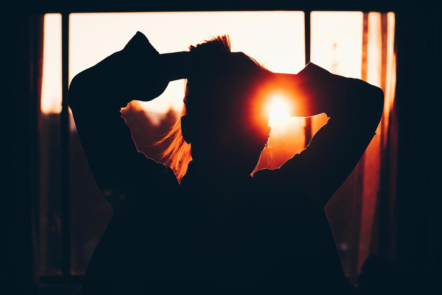 silhouette di donna che tiene i capelli foto