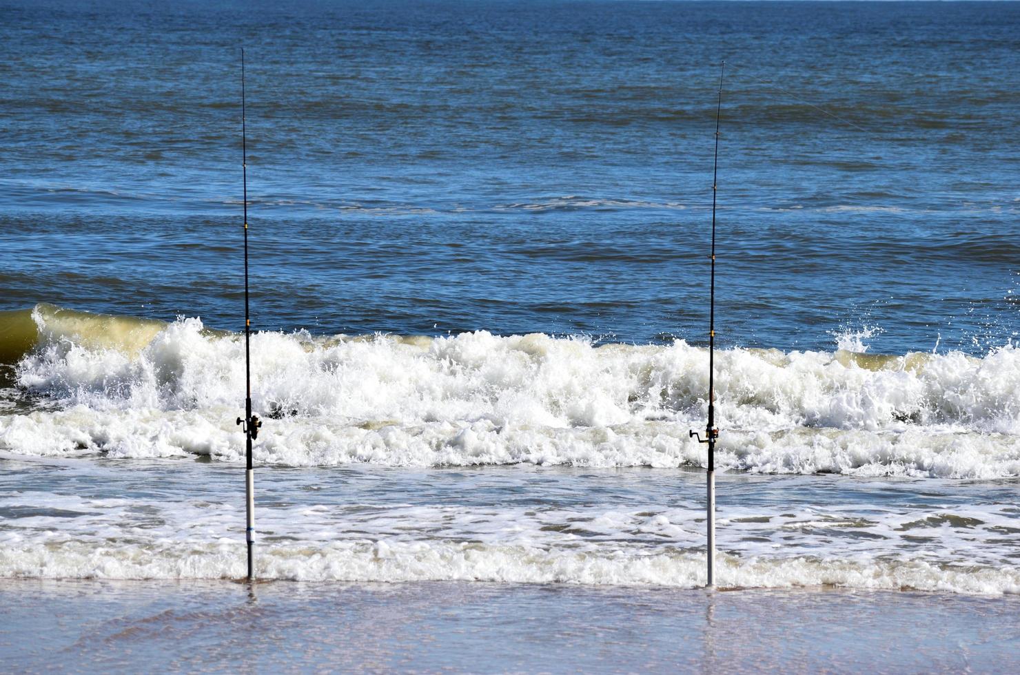 canne da pesca sulla spiaggia foto