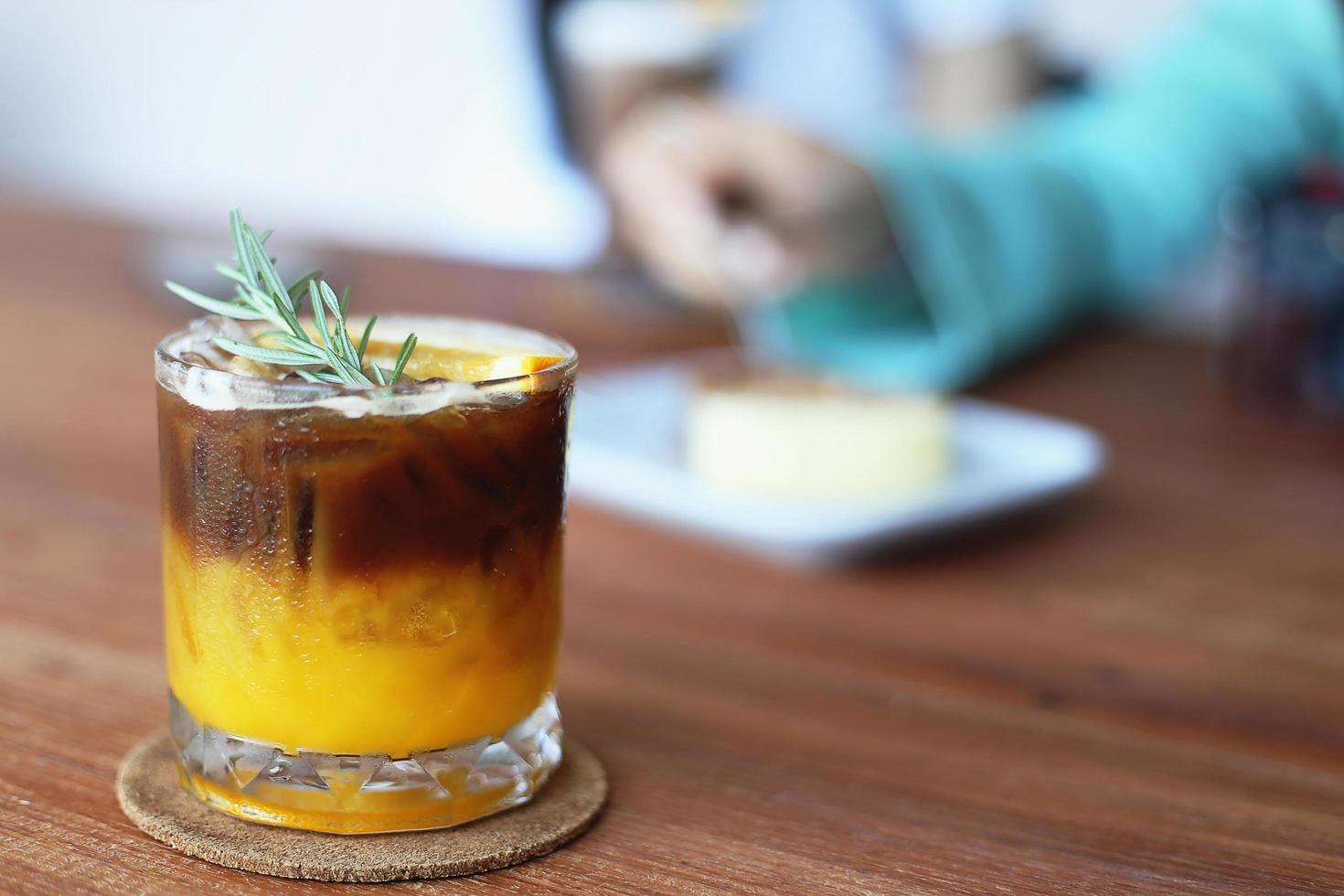 cocktail di caffè arancione sulla tavola di legno nella caffetteria foto