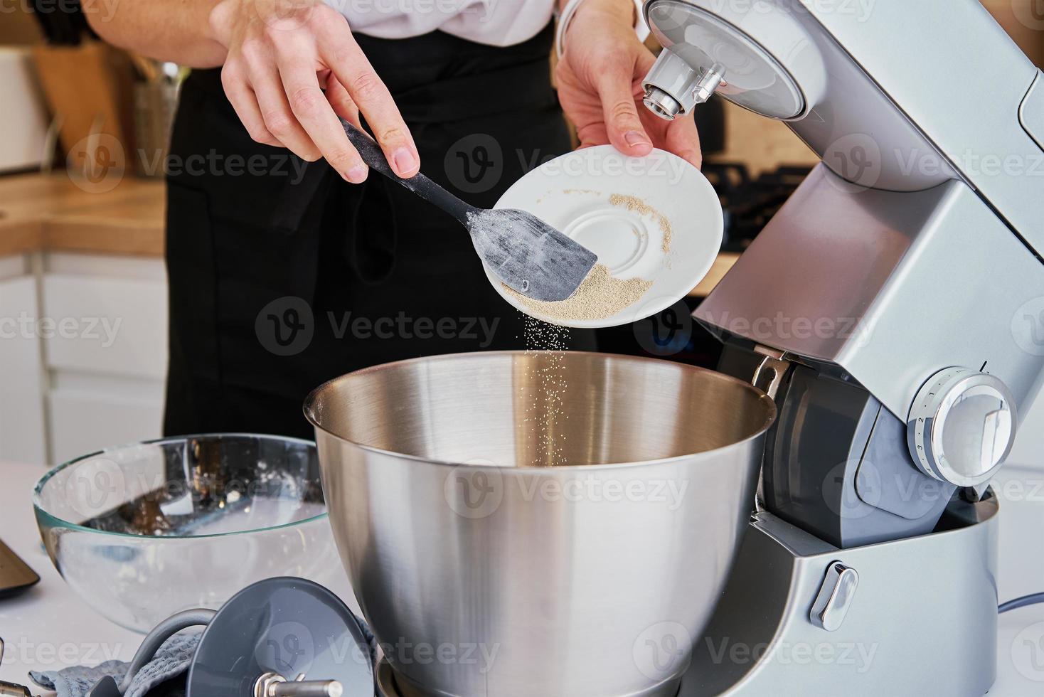 donna cucinando a cucina e utilizzando cucina macchina foto