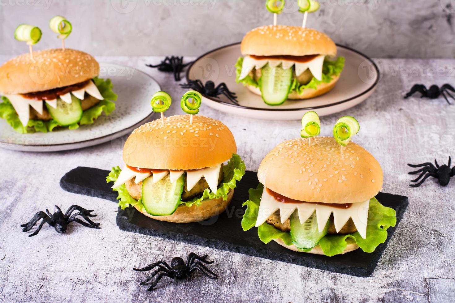 fatti in casa mostro hamburger con occhi e lingua per Halloween menù su ardesia e ragni su il tavolo foto