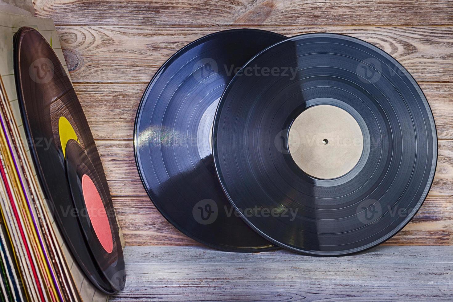 un' mucchio di vecchio vinile record In piedi su un' mensola contro il sfondo di un' di legno parete foto