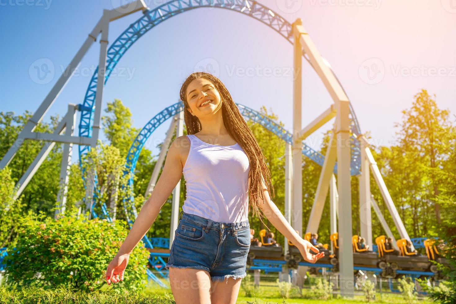 contento Sorridi ragazza sta nel un divertimento parco su un' soleggiato giorno. di moda ritratto . foto