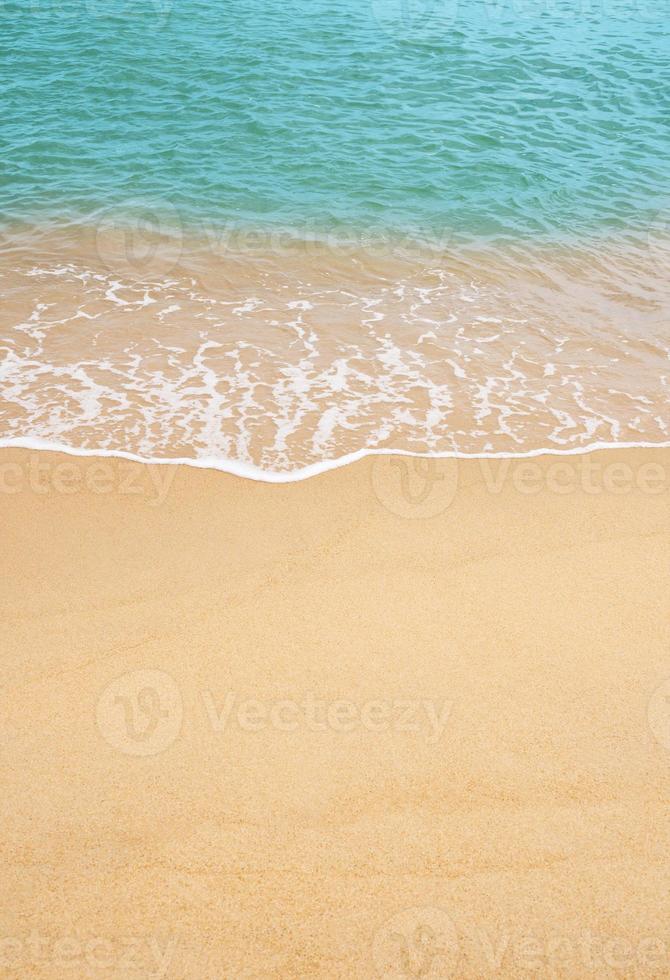 sabbia spiaggia e blu oceano con morbido onda modulo su sabbia struttura, Marrone spiaggia sabbia duna nel soleggiato giorno molla, verticale superiore Visualizza per estate bandiera sfondo. foto