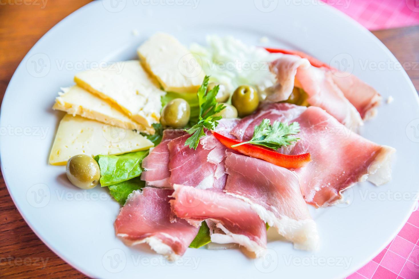 piatto di specialità gastronomiche con formaggio prosciutto e olive foto