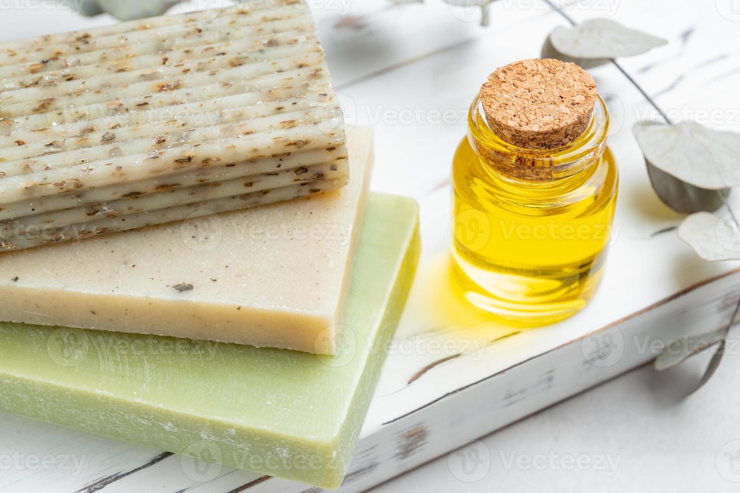 biologico naturale sapone barre con impianti estratti, fatto a mano saponi su legno vassoio con essenziale olio e eucalipto ramo. fatti in casa naturale cosmetici. foto