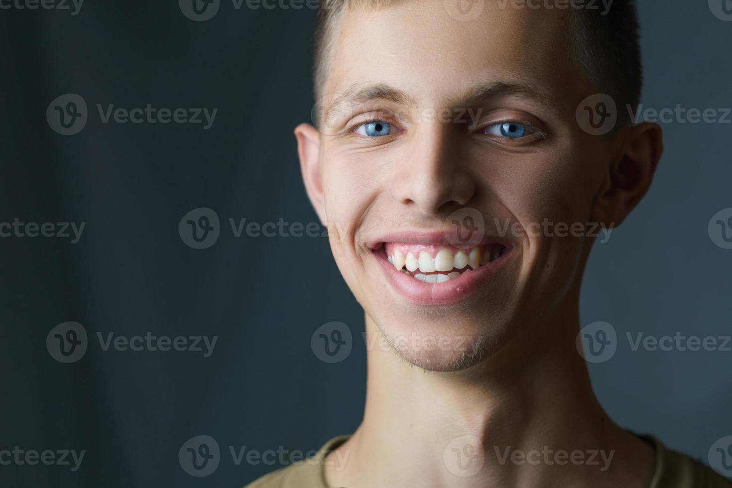 avvicinamento ritratto di un' giovane uomo sorridente nel il sfondo foto