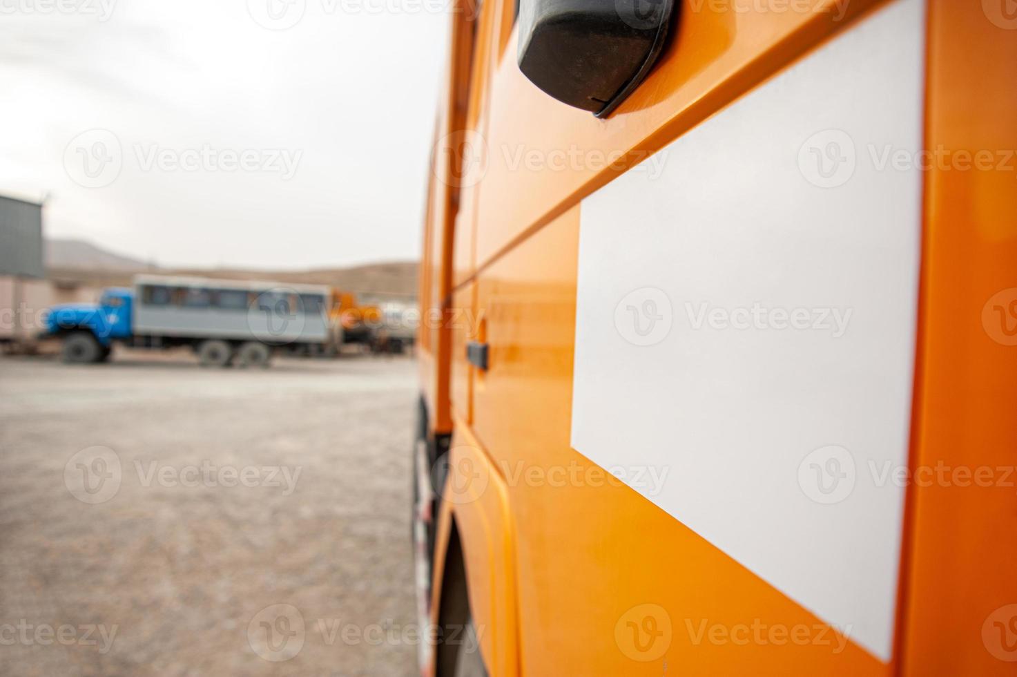 un' avvicinamento di un arancia cumulo di rifiuti camion porta a un' costruzione luogo foto