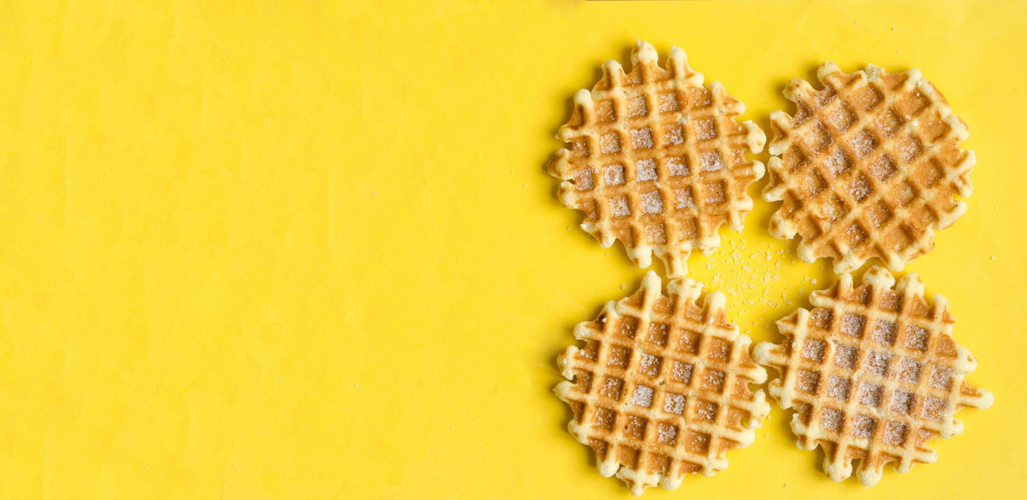 superiore Visualizza, quattro zucchero Belgio cialde su giallo sfondo, copyspace.dolce dolce. foto