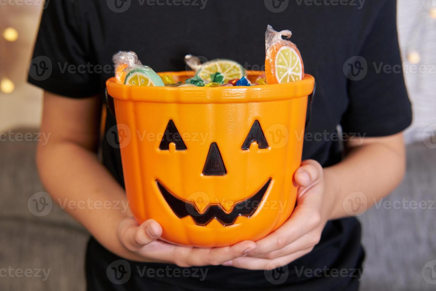 un' ragazzo nel scheletro trucco tira su caramella a partire dal un' Halloween festa. foto