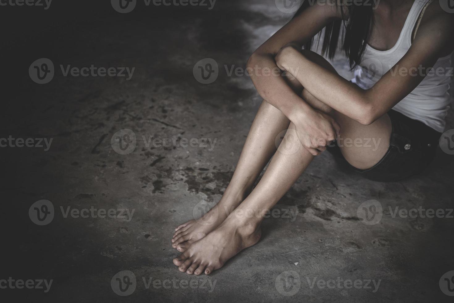 impaurito giovane donna seduta nel il angolo di sua Camera da letto, disperazione stupro vittima in attesa per aiuto, il concetto di sosta violenza contro donne e stupro. foto